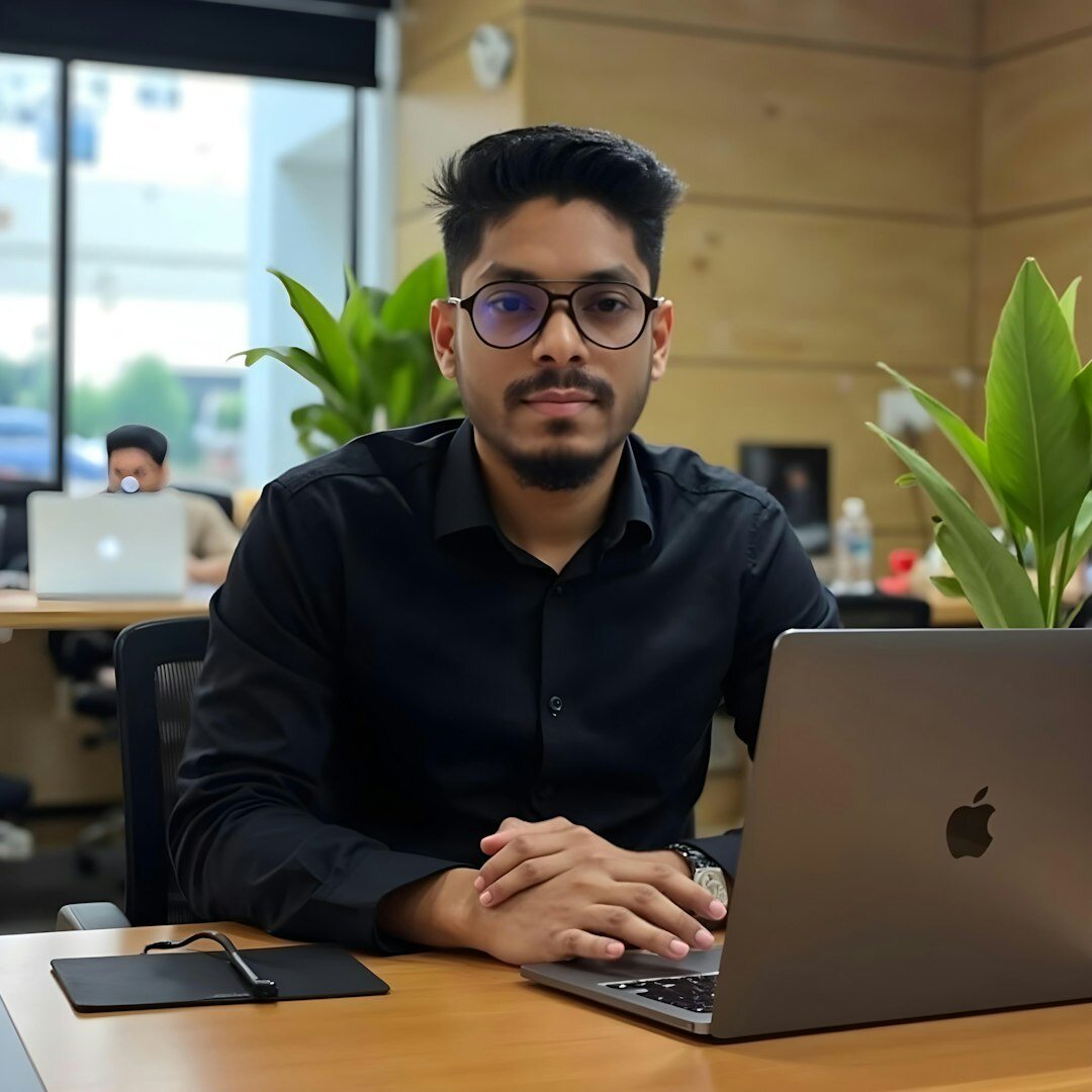 Happy male student using laptop in modern setting